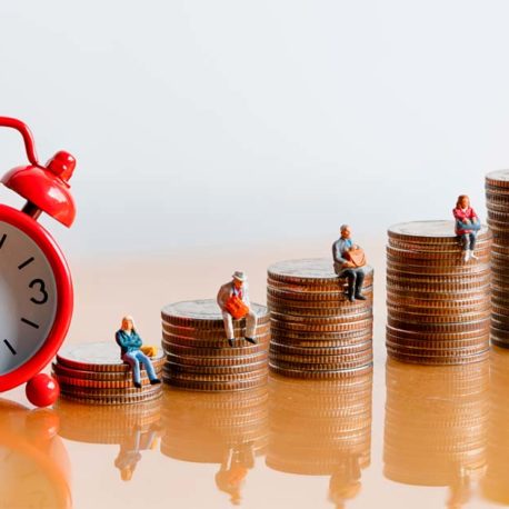 Herätyskello, kolikkokasoja vierekkäin, niiden päällä ihmishahmoja.