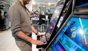 Mies pelaa rahapelejä kaupassa