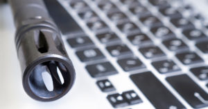 Aseen piippu näppäimistön edessä