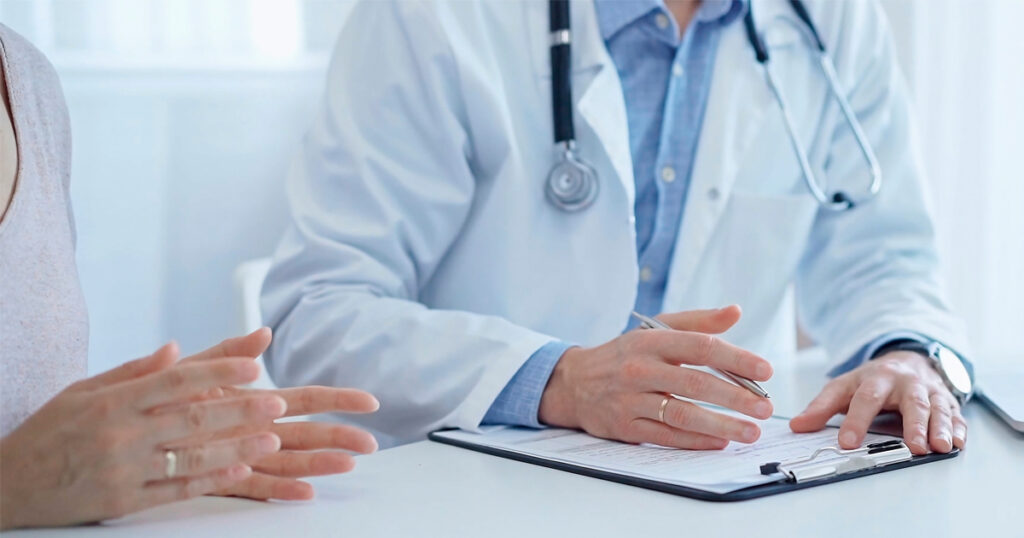 Lääkäri ja potilas katselevat papereita