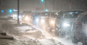 Autoja ruuhkassa lumisateessa