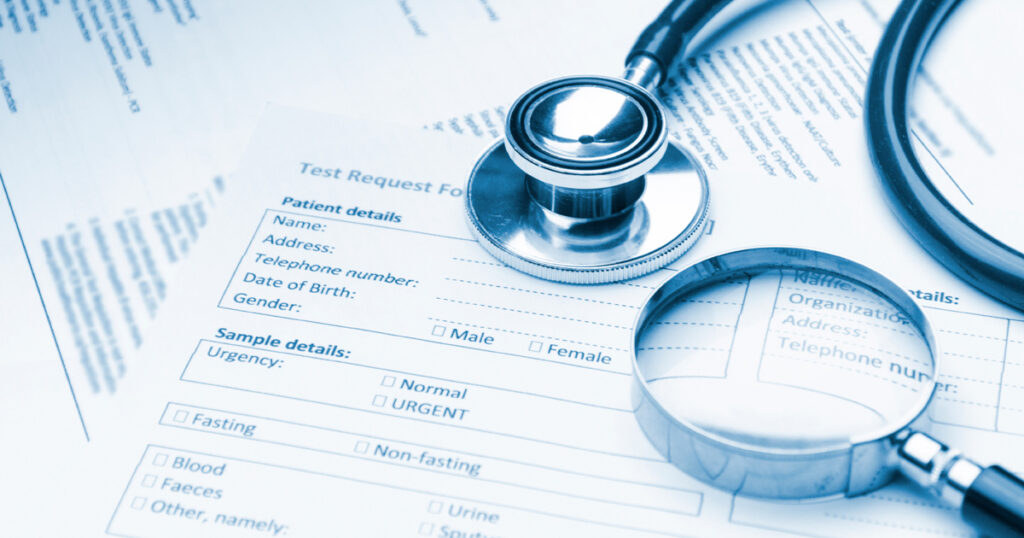 Terveystietopapereita, suurennuslasi ja stetoskooppi.